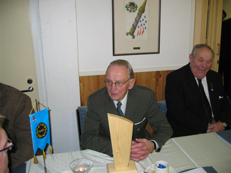 Painijaoston kunniapuheenjohtaja Kalevi Holma ja Painiliiton 100-vuotisjuhlapysti, taustalla hymyilee Toivo Lautaoja.